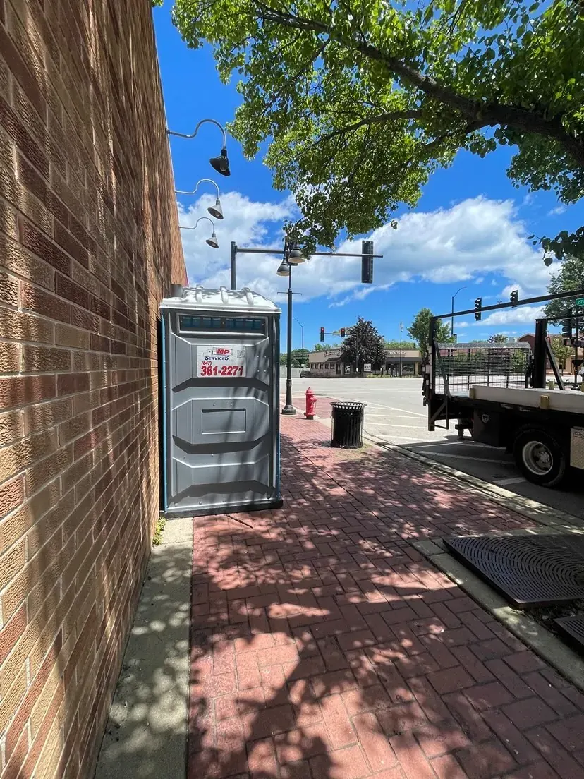 A single standard portable toilet on a downtown Zion street corner