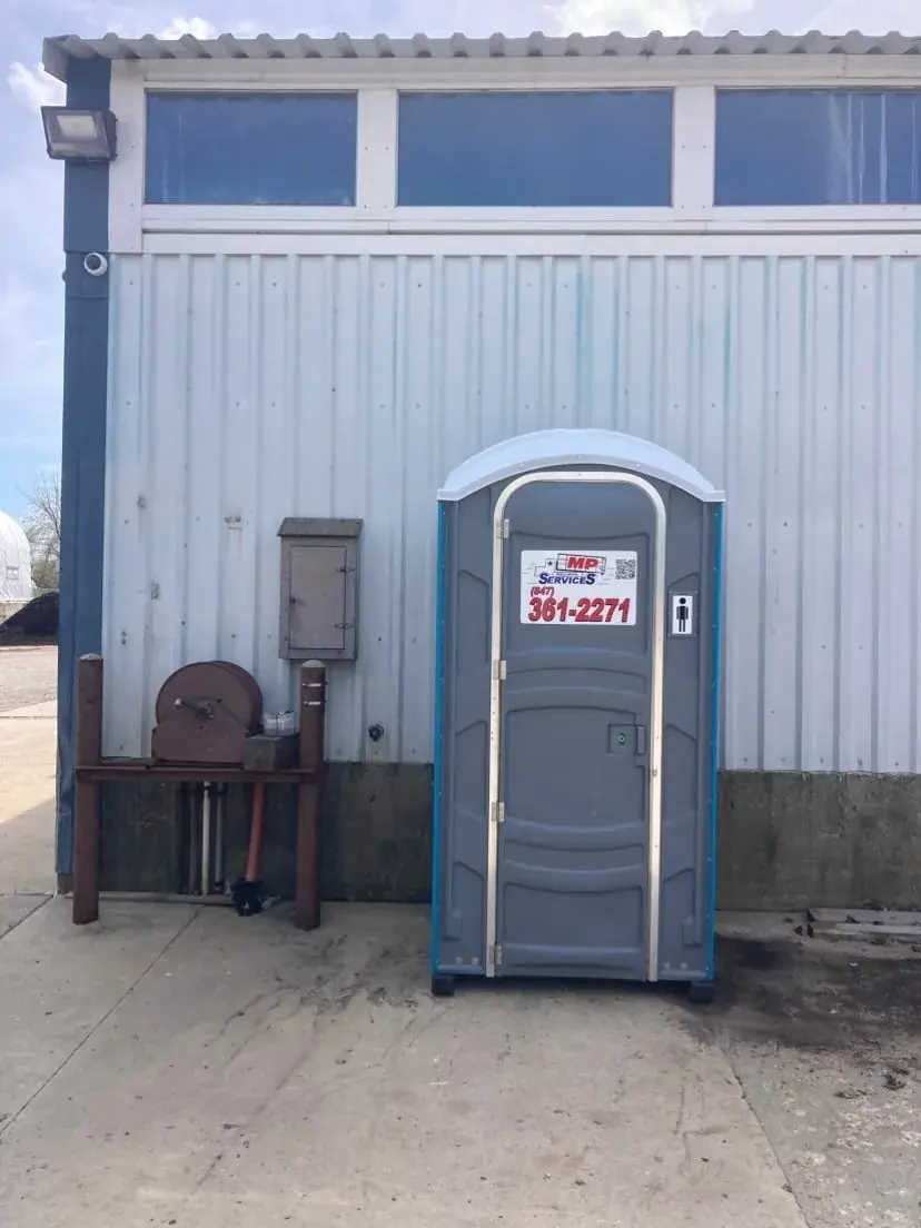 A gray MP Sanitation standard portable toilet placed on a Lake County job site